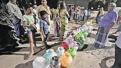கோவை உப்பிலிபாளையத்தி்ல், சாலையோர பொதுக்குழாயில் குடிநீர் பிடிக்க காலி குடங்களுடன் நீண்ட வரிசையில் காத்திருந்த மக்கள். படம்: ஜெ.மனோகரன்