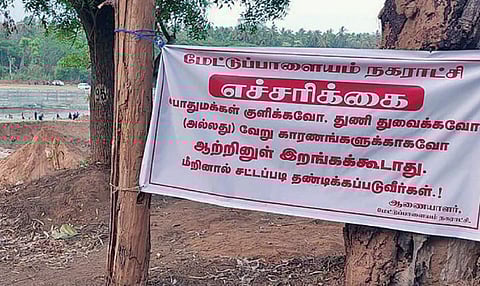 மேட்டுப்பாளையம் பவானிஆற்றின் கரையோரத்தில் சாமண்ணா வாட்டர் ஹவுஸ் பகுதியில் நகராட்சி நிர்வாகத்தால் வைக்கப்பட்டுள்ள எச்சரிக்கை பேனர்.