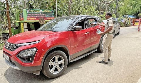 பழநி மலையடிவாரத்தில் சுற்றுலாப் பயணிகளிடம் இருந்து தண்ணீர் பாட்டில்களை பறிமுதல் செய்த வனக்காவலர்.