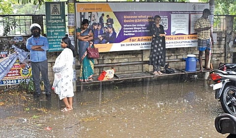 கோவையில் நேற்று மாலை சூறைக்காற்றுடன் மழை பெய்தது. சிங்காநல்லூர் உழவர் சந்தை அருகே உள்ள பேருந்து நிறுத்தத்தில் மழைநீர் தேங்கியதால் இருக்கை மீது ஏறி நின்ற பயணிகள். படம்: ஜெ.மனோகரன்.