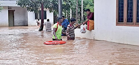 கூடலூர் அருகே இருவயல் பகுதியில் மழை நீர் புகுந்த வீட்டுக்குள் சிக்கிய நபர்களை மீட்கும் தீயணைப்புத் துறையினர்.
