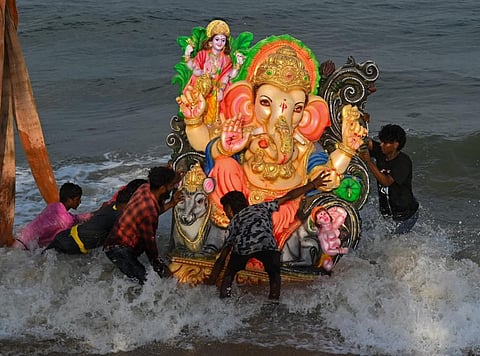 சென்னை பட்டினப்பாக்கம் சீனிவாச புரம் கடலில் பெரிய அளவிலான விநாயகர் சிலையை தன்னார்வலர்கள் தூக்கி சென்று கடலில் கரைக்கின்றனர். | படம்: எஸ்.சத்தியசீலன்