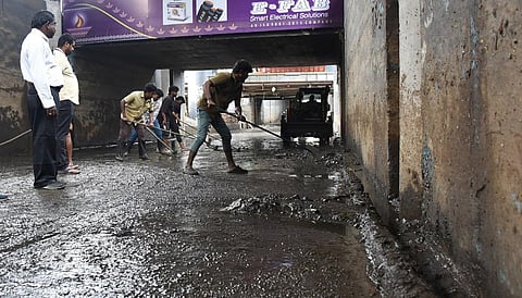 கோவை அவிநாசி சாலை அண்ணா மேம்பாலத்தின் கீழ் பகுதியில் தேங்கிய மழைநீரை அகற்றும் பணியில் ஈடுபட்ட மாநகராட்சி ஊழியர்கள். படம்: ஜெ.மனோகரன்.