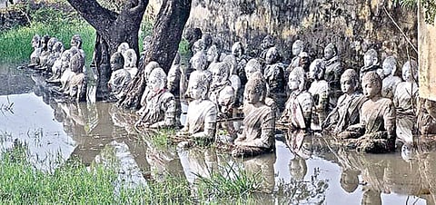 அமராவதியில் சேற்றில் கிடக்கும் தியான புத்தர் சிலைகள்.