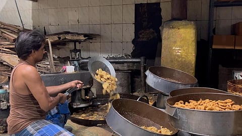 தீபாவளிப் பண்டிகையை முன்னிட்டு, காரமடை அருகே கை முறுக்கு தயாரிப்புப் பணியில் ஈடுபட்டுள்ள தொழிலாளர்கள்.