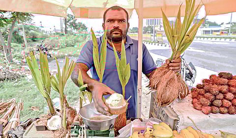 கிருஷ்ணகிரியில் சாலையோரம் தள்ளுவண்டி கடையில் தேங்காய்ப்பூ விற்பனையில் ஈடுபட்டுள்ள சிறு வியாபாரி.