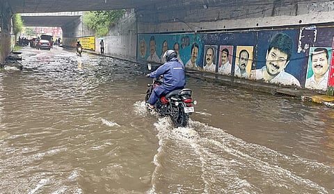 தாம்பரம் அடுத்த இரும்புலியூர் பாலத்தின் கீழ் தேங்கியுள்ள மழைநீரில் செல்லும் வாகனங்கள். | படம்: எம்.முத்துகணேஷ் |