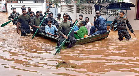 புதுச்சேரி கிருஷ்ணா நகரில் மழைநீர் சூழ்ந்த குடியிருப்புப் பகுதிகளிலிருந்து பொதுமக்களை மீட்டு, படகில் அழைத்து வரும் துணை ராணுவ மீட்புப் படையினர். படம்: எம்.சாம்ராஜ்