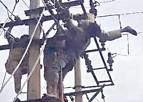 எம்.குன்னத்தூர் கிராம மின் மாற்றியில் சிக்கிய ஏழுமலையை மீட்கும் சக ஊழியர்கள்.