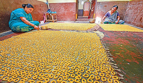 தஞ்சாவூர் அருகே புன்னைநல்லூர் மாரியம்மன் கோயிலைச் சுற்றியுள்ள தெருக்களில் உள்ள வீடுகளில் மட்டுமே குடிசைத் தொழிலாக பெண்கள் குச்சி முறுக்கு செய்யும் பணியில் குடும்பத்துடன் ஈடுபட்டுள்ளனர். | படங்கள்: ஆர்.வெங்கடேஷ் |