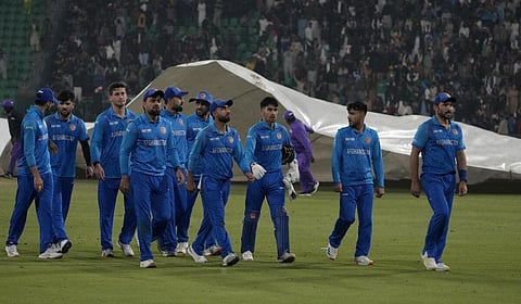 மழை காரணமாக பெவிலியனுக்குத் திரும்பும் ஆப்கன் வீரர்கள்.