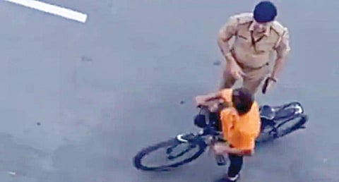 குஜராத் மாநிலம் சூரத் மாவட்டம் லிம்பாய் பகுதியில் சிறுவனை மடக்கி விசாரிக்கும் போலீஸ் எஸ்.ஐ. காத்வி.