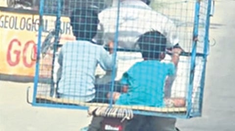 கோழிக்கூண்டில் அமர்ந்து தந்தை பைக்கில் பயணித்த மகன்கள்