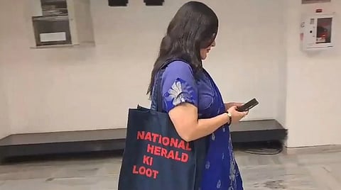 நேஷனல் ஹெரால்ட் கொள்ளை வாசகம் எழுதப்பட்ட பையுடன் வந்த பாஜக எம்.பி.