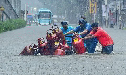 மகாராஷ்டிரா தலைநகர் மும்பையில் கடந்த 3 நாட்களாக கனமழை பெய்து வருகிறது. முக்கிய சாலை சந்திப்புகளில் மழைநீர் சூழ்ந்ததால், மக்களின் இயல்பு வாழ்க்கை முடங்கியுள்ளது. நேற்று கடும் மழை பெய்த நிலையில், வெள்ளத்தின் நடுவே மிகவும் சிரமப்பட்டு, மூன்று சக்கர வாகனத்தில் சமையல் எரிவாயு சிலிண்டர்களை எடுத்து வரும் ஊழியர்கள்.படம்: பிடிஐ