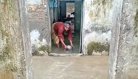 திருவாரூர் அழகிரி காலனி பகுதியில் வீட்டுக்குள் புகுந்த மழைநீரை வெளியேற்றும் பெண்.