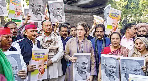 நாடாளுமன்ற வளாகத்தில் உள்ள காந்தி சிலை அருகே, புதிய ஊரக வேலை உறுதி மசோதாவுக்கு எதிராக எதிர்க்கட்சிகள் சார்பில் நேற்று போராட்டம் நடைபெற்றது. இதில் காங்கிரஸ் பொதுச் செயலாளர் பிரியங்கா காந்தி, சமாஜ்வாதி தலைவர் அகிலேஷ் யாதவ், திமுக எம்.பி. டி.ஆர்.பாலு உள்ளிட்டோர் மகாத்மா காந்தியின் புகைப்படத்தை கையில் ஏந்தியபடி பங்கேற்றனர்.படம்: பிடிஐ