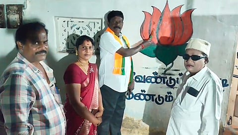 நிலக்கோட்டை தொகுதியில் சின்னம் வரைந்து பிரச்சாரத்தில் ஈடுபட்டுள்ள முன்னாள் எம்எல்ஏவும் பாஜக பிரமுகருமான அன்பழகன்.