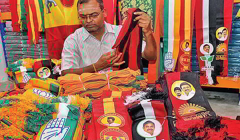 திருப்பூரில் விற்பனைக்கு வைக்கப்பட்டுள்ள அரசியல் கட்சிகளின் துண்டுகள், கொடிகள்.