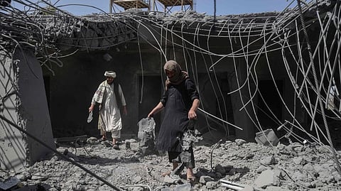 பாக். போர் விமானங்கள் குண்டு வீசியதில், காந்தகாரின் டாமன் மாவட்டத்தில் சேதமடைந்த கட்டிடத்தில் கிடந்த குண்டு துகள்களை தலிபான் படையினர் காட்டுகின்றனர்.