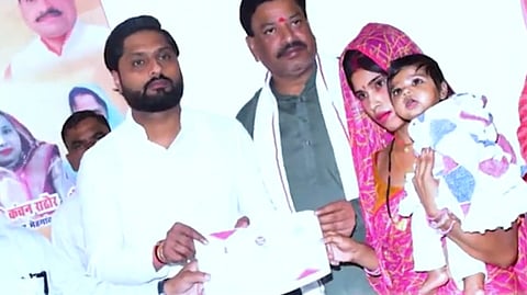 பயனாளிகளுக்குச் சான்றிதழ்களை வழங்கும் அமைச்சர் ராகேஷ் சுக்லாவின் மகன் அலோக் சுக்லா