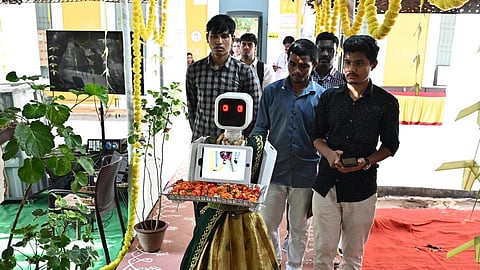 புதுச்சேரி வஉசி பள்ளி வாக்குச்சாவடியில் பூக்கள் கொடுத்து வரவேற்ற பெண் ரோபோ