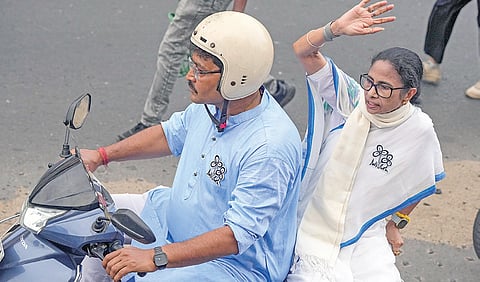 மேற்கு வங்க முதல்வர் மம்தா பானர்ஜி கொல்கத்தாவில் நேற்று தொண்டர் ஒருவரின் ஸ்கூட்டரில் பயணித்தபடி இறுதிக்கட்ட பிரச்சாரம் செய்தார். படம்: பிடிஐ