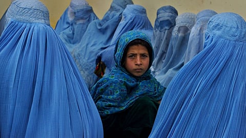Women wait in line to be treated at a health clinic in Kalakan, Afghanistan, in February 2003