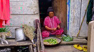 An elderly Monpa woman preparing Solu chillies for preservation