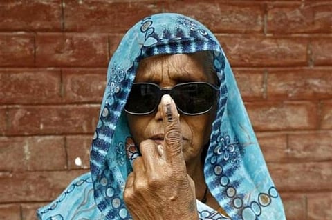 An Indian woman showing the camera her marked finger after voting.