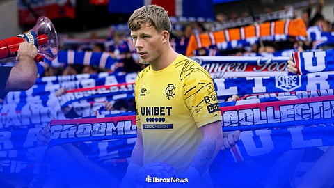 Anthony Patterson in a Rangers kit, with supporters behind him
