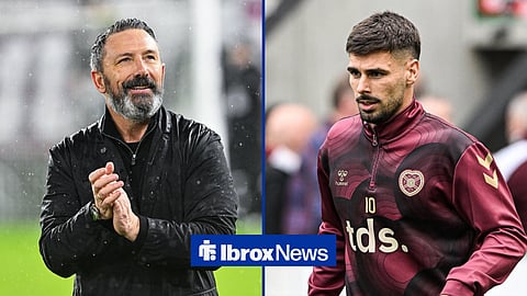 Derek McInnes, former Hearts boss, smiling at Tynecastle Park next to Claudio Braga, who is warming up in a training jacket.