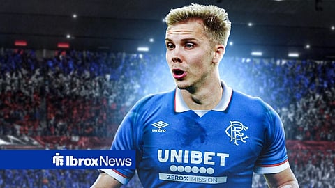 Oliver Antman looking left in action for Rangers ahead of glowing Ibrox background