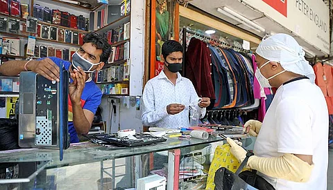 A shopkeeper repairs a customer’s laptop. The government has announced fresh PLI schemes to 12 sectors. The newly announced PLI schemes by the government includes telecom and network equipment makers, pharmaceuticals and IT hardware such as laptops, tablets, PCs and servers.