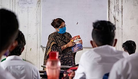 A teacher interacting with students in a classroom. This image will soon be a thing of the past as the rise of ed-tech ensures a transformational change in classrooms.