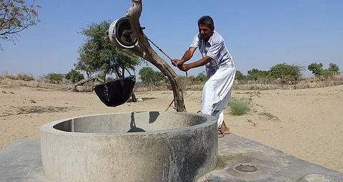 Water being fetched in India with a pulley from a well with circular wall