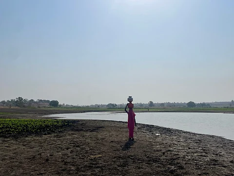 Sita balances nearly 20 litres of water on her head. This is her third trip today, walking back under the harsh Melghat sun.