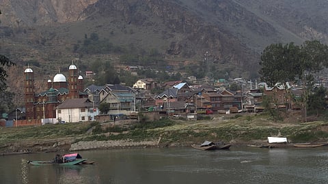 Boats line the banks of the Jhelum River as workers prepare to collect sand, a common practice in Kashmir despite restrictions on riverbed mining.