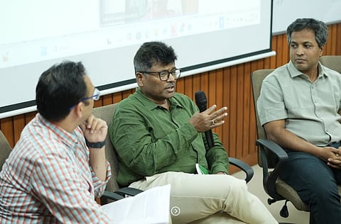 A panel discussion moderated by Divyang Waghela, Tata Trusts (L). Panelists seen are Manas Satpathy, PRADAN (M) and Sunderrajan Krishnan, INREM (R).