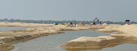Riverbed sand mining on the Damodar near Nabagram village in West Bengal, showing an influx of JCBs and trucks on the riverbed. The various anthropogeomorphic landforms induced by sand mining are also visible such as, sand mounds, excavated sand pools, and levelled sand tracks created by mining activity.