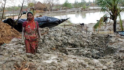 A woman searching for her utensils in debris of her house which collapsed after Cyclone Aila (Image: Anil Gulati, Wikimedia Commons)