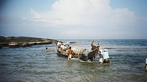 Fishermen launching their boat into the sea