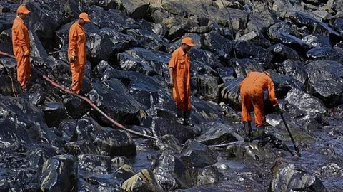 Oil sludge being manually removed from the rocky coast. (Image courtesy: The Indian Express)
