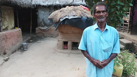 Renupada Bagdi in front of his thatched house. (Photo: Gurvinder Singh)