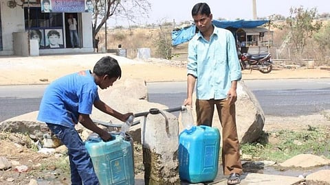 People take water from a common water point. (Source: SaciWATERs)