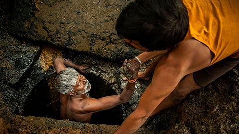 A latrine emptier is lifted out of a pit in Bangalore, India (Image: WaterAid/CS Sharada Prasad)