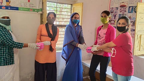 ज़रूरतमंद किशोरियों को नैपकिन बांटती समूह की सदस्या