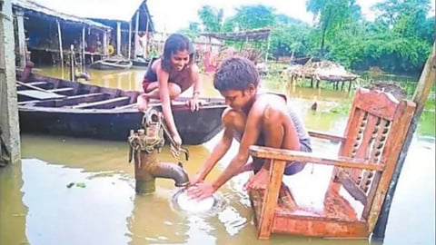 बाढ़ में डूबे चापाकल से पानी लेते मासूम