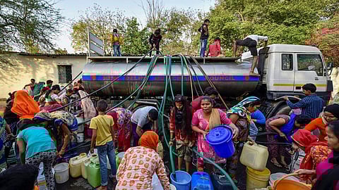 दिल्ली में पानी का संकट, टैंकर से पीने का पानी भरते लोग।