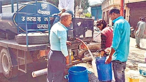 चंपावत में जीआईसी रोड पर टैंकर से पानी ले रहे लोग